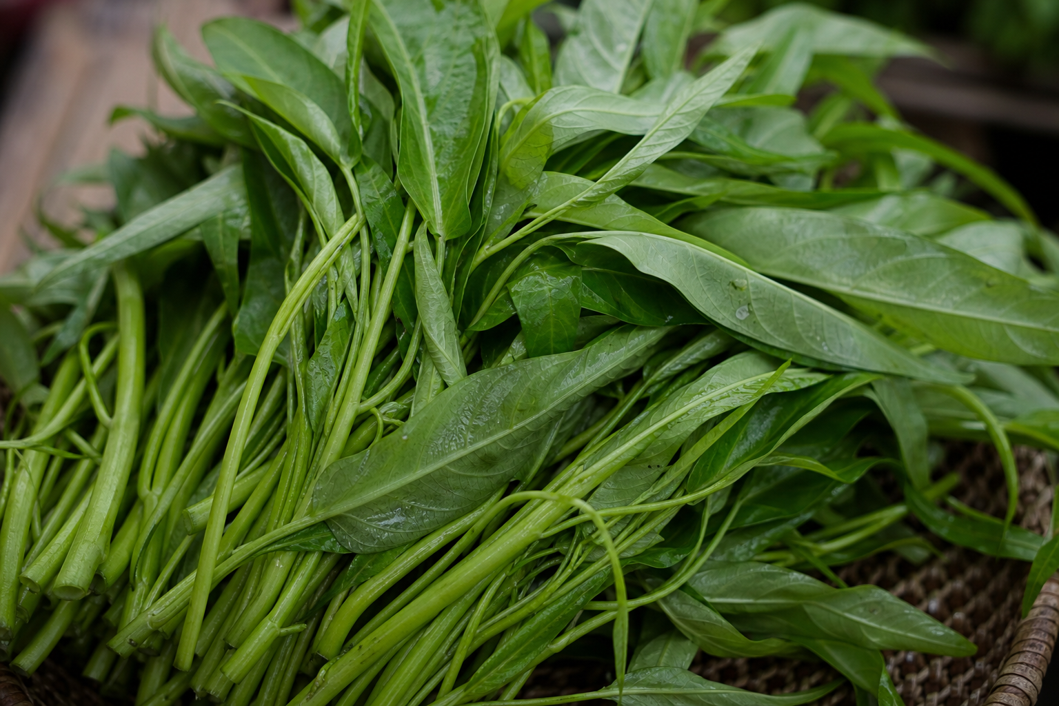 Daun kangkung segar, sumber kalsium nabati yang mudah diakses di Indonesia.