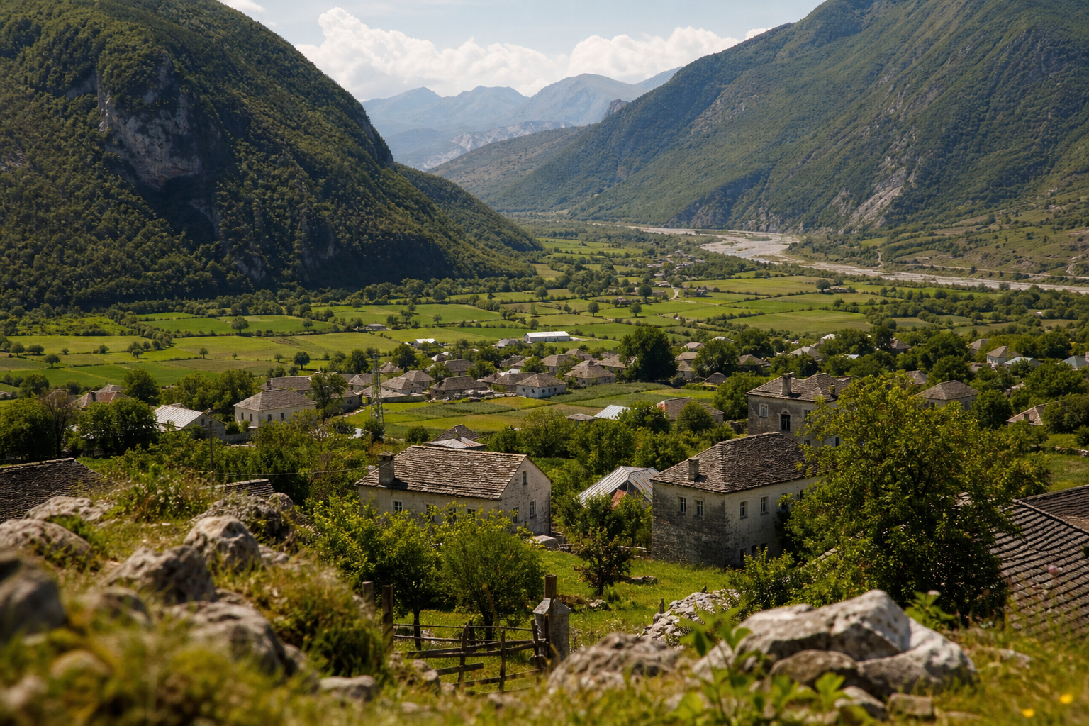 Pamje panoramike e një fshati malor shqiptar me shtëpi tradicionale të vendosura në luginë.