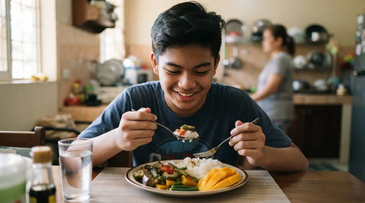 Isang teenager na Pilipino na kumakain ng kanin na may gulay